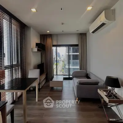 Modern living room with city view, featuring sleek furniture and large windows for natural light.