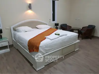 Spacious bedroom with elegant decor and cozy seating area