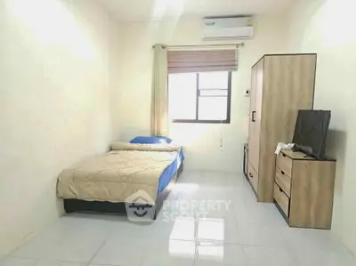 Cozy bedroom with modern furniture and air conditioning, perfect for comfortable living.