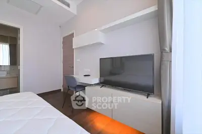Modern bedroom with sleek furniture and large TV, perfect for relaxation and entertainment.