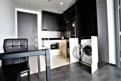Modern kitchen with sleek appliances and open layout in stylish apartment.