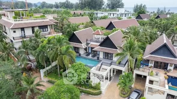 Luxurious tropical villas with private pools and lush greenery near the beach.