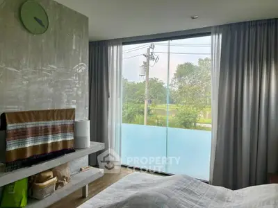 Cozy bedroom with large window offering serene garden view, modern decor, and soft lighting.