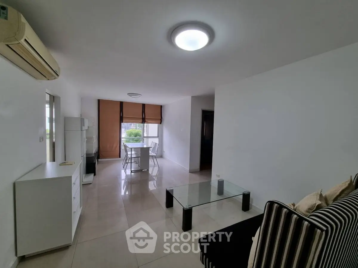 Spacious modern living room with sleek furniture and natural light, perfect for relaxation and entertaining.
