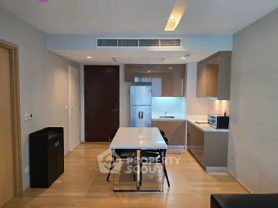 Modern kitchen with sleek cabinetry and dining area in contemporary apartment