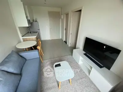 Modern compact living room with sleek furniture and open kitchen layout