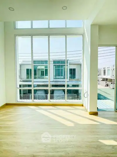 Spacious modern living room with large windows and abundant natural light in a contemporary home.
