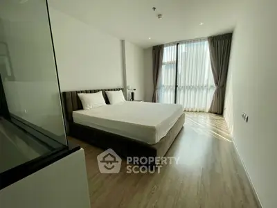 Spacious modern bedroom with large window and elegant decor
