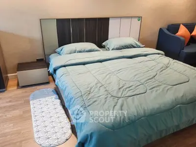 Modern bedroom with stylish bed and cozy seating area, perfect for relaxation and comfort.