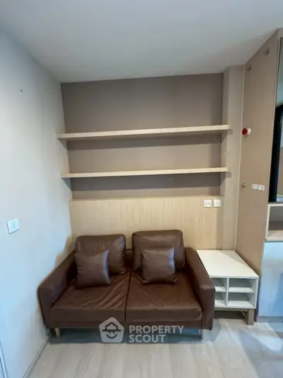 Modern living room with sleek shelving and cozy brown leather sofa
