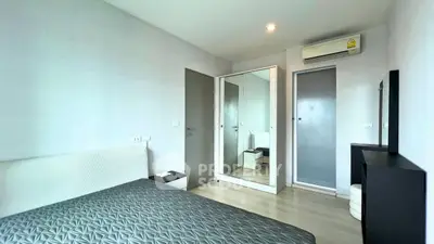 Modern bedroom with sleek design, featuring a mirrored wardrobe and air conditioning for comfort.