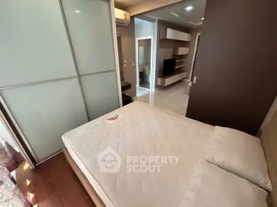 Modern bedroom with sliding door and built-in storage in a stylish apartment.