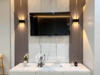 Modern living room with wall-mounted TV and elegant lighting