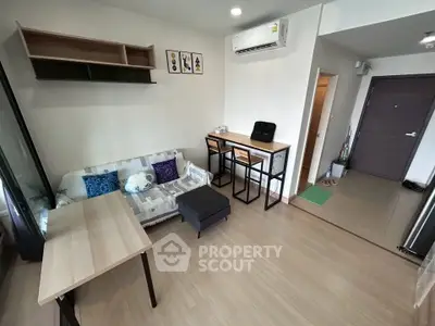 Modern living room with stylish decor and compact dining area, featuring sleek furniture and wooden flooring.