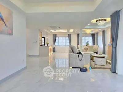 Spacious modern living room with elegant decor and open layout, featuring a luxurious chandelier and stylish furniture.
