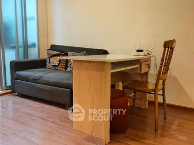 Cozy living room with modern sofa and wooden desk, perfect for a home office setup.