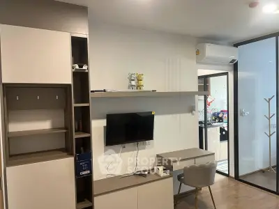 Modern living room with sleek furniture and open kitchen layout in a stylish apartment.