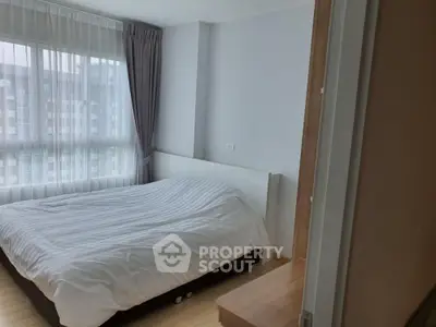 Cozy bedroom with large window and modern decor in urban apartment