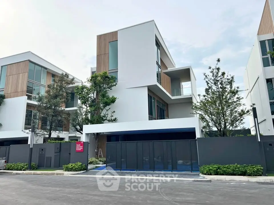 Modern multi-story house with sleek design and lush greenery in a serene neighborhood.
