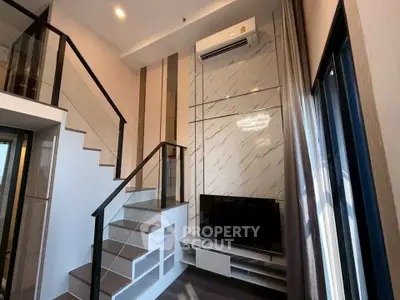 Modern duplex living room with stylish staircase and large TV setup