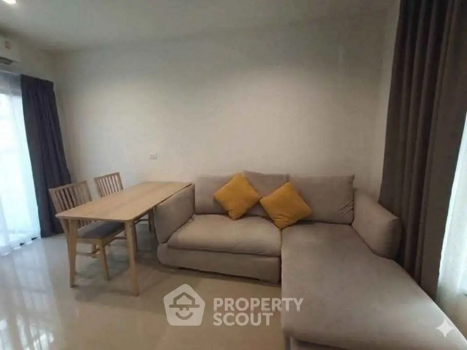 Cozy living room with modern sofa and dining table, perfect for relaxation and entertaining.