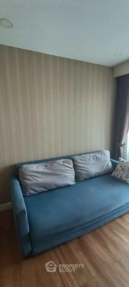 Cozy living room with blue sofa and elegant wallpaper, perfect for relaxation.