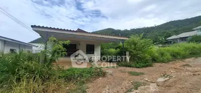 Charming rural house with covered porch and lush greenery, perfect for nature lovers seeking tranquility.