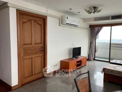 Spacious living room with balcony and city view, featuring modern furniture and air conditioning.