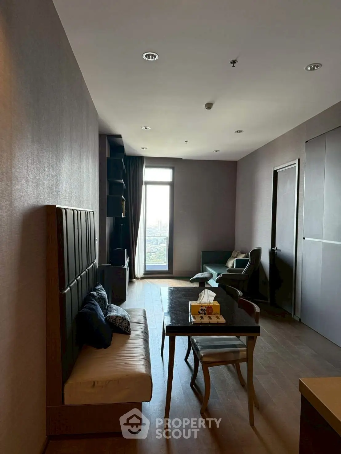 Modern living room with city view, stylish furniture, and natural light.