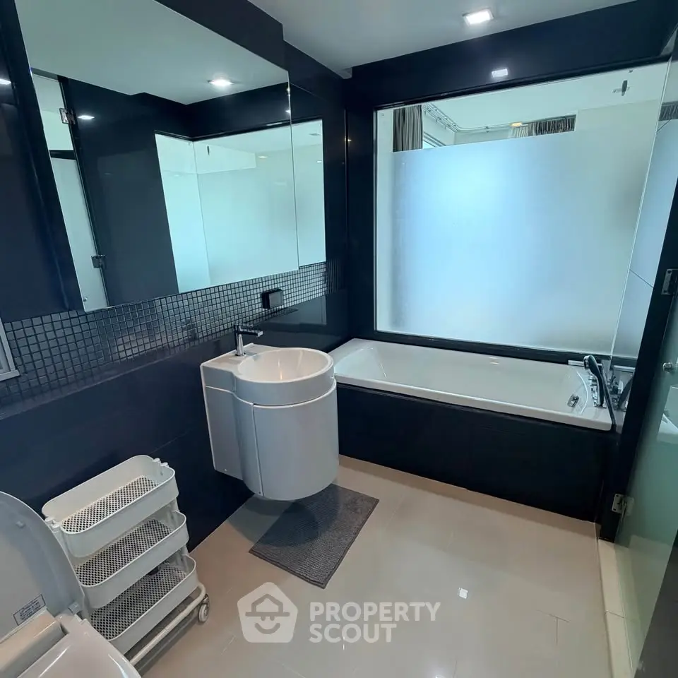 Modern bathroom with sleek design and spacious bathtub in luxury apartment.