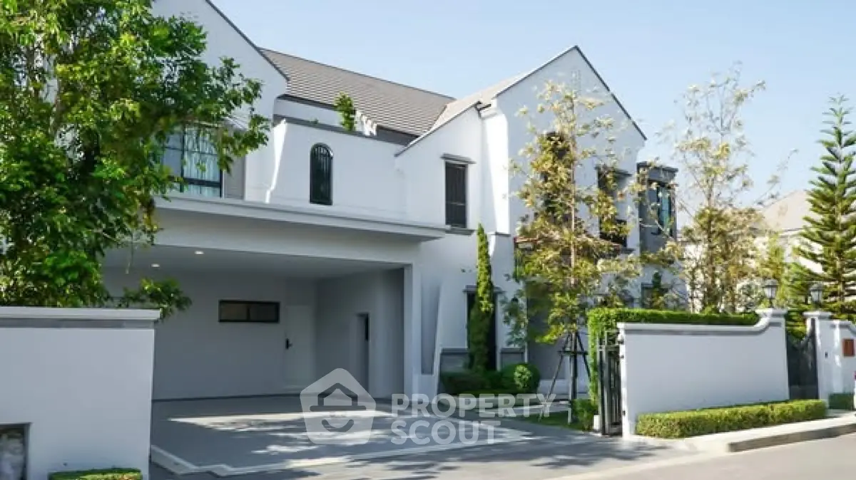 Elegant modern house with spacious driveway and lush greenery, perfect for luxurious living.