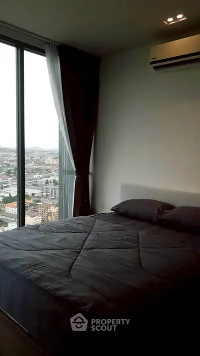 Modern bedroom with large window offering stunning city view, featuring sleek design and cozy ambiance.