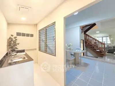 Spacious open-plan living area with modern kitchen and elegant staircase