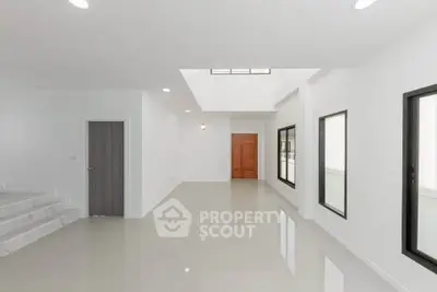 Spacious modern living room with skylight and sleek tile flooring