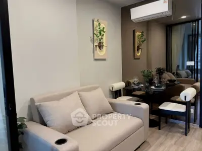 Modern living room with cozy sofa and dining area, featuring stylish decor and air conditioning.