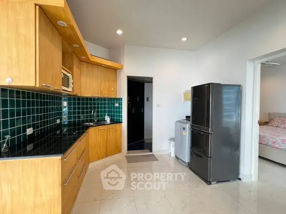 Modern kitchen with wooden cabinets and sleek appliances in open layout.