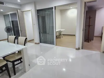 Spacious modern apartment with open layout and elegant dining area, featuring sleek white flooring and contemporary furniture.