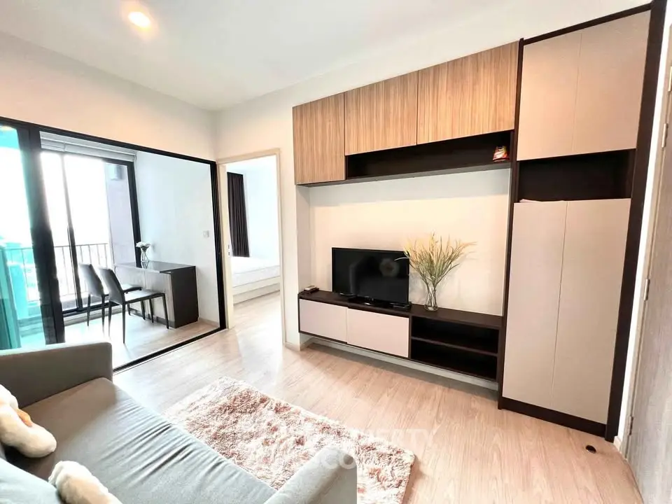 Modern living room with stylish furniture and open layout leading to a balcony, perfect for urban living.