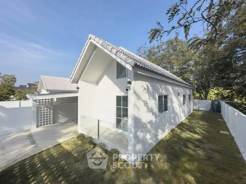 Charming modern white house with sloped roof and spacious garden, perfect for family living.