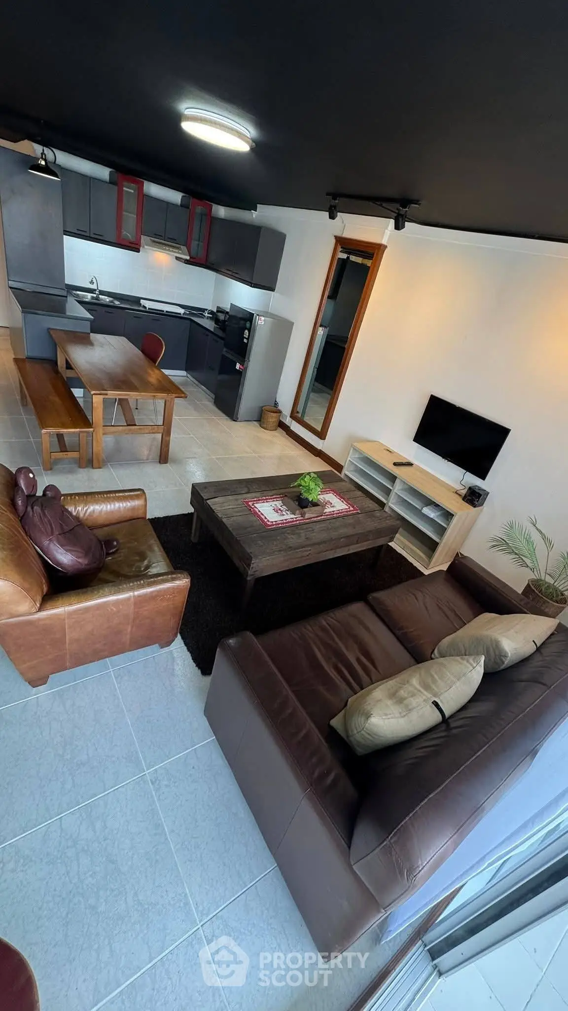 Modern open-layout living room with stylish kitchen and cozy seating area.