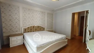 Elegant bedroom with classic decor and wooden flooring in a cozy apartment.
