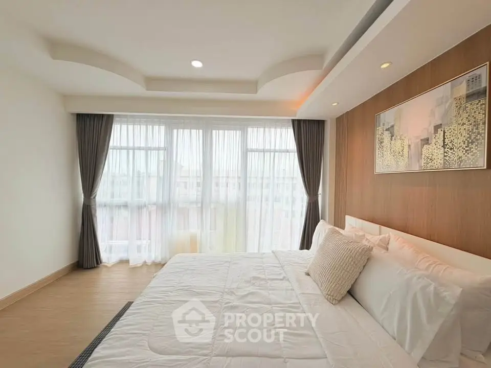 Spacious modern bedroom with large windows and elegant decor