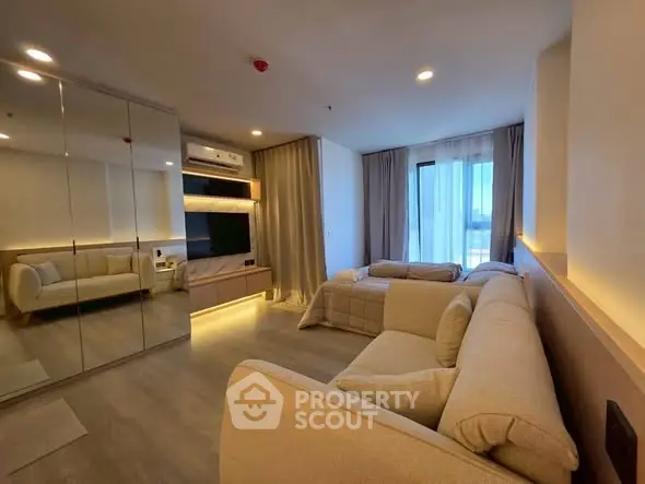 Modern living room with cozy sofas and mirrored wardrobe, featuring elegant lighting.