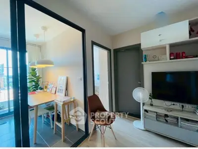 Modern living room with stylish decor and dining area, featuring natural light and contemporary furniture.