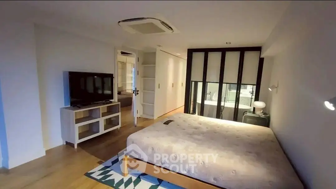 Spacious modern bedroom with stylish decor and ambient lighting