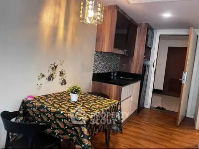 Charming compact kitchen with stylish dining area and modern lighting in cozy apartment.