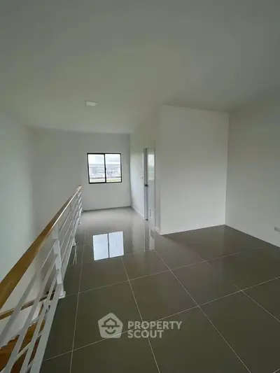 Spacious modern interior with sleek tile flooring and large window for natural light.