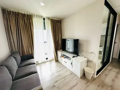 Modern living room with sleek TV setup and large window drapes