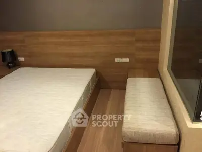 Cozy bedroom with modern wooden accents and comfortable seating area.