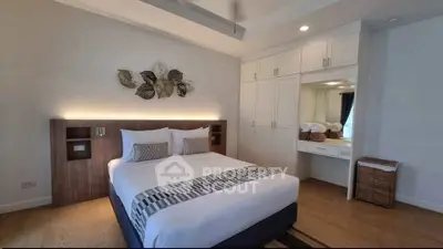 Spacious bedroom with modern decor and ample storage in a stylish apartment.